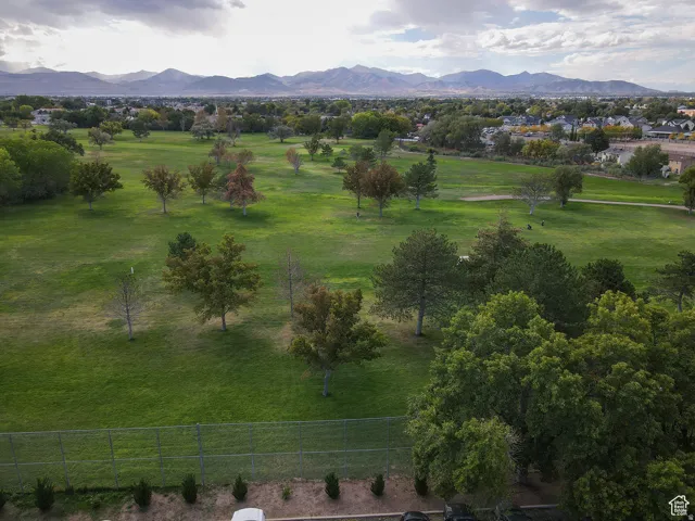 Expansive green space featuring mature trees and a distant mountain range
