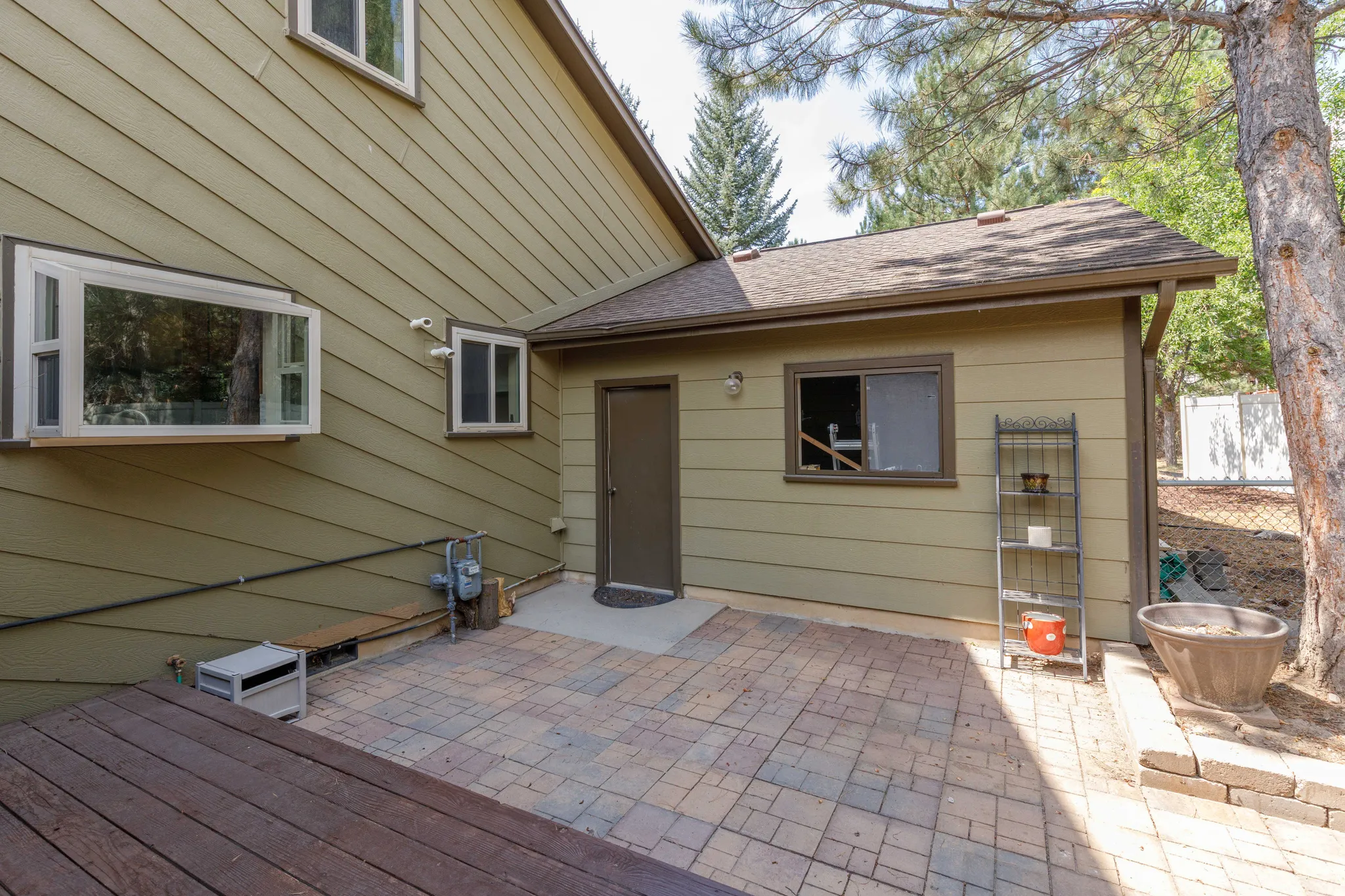 Patio area with paver flooring, adjacent to a wooden deck