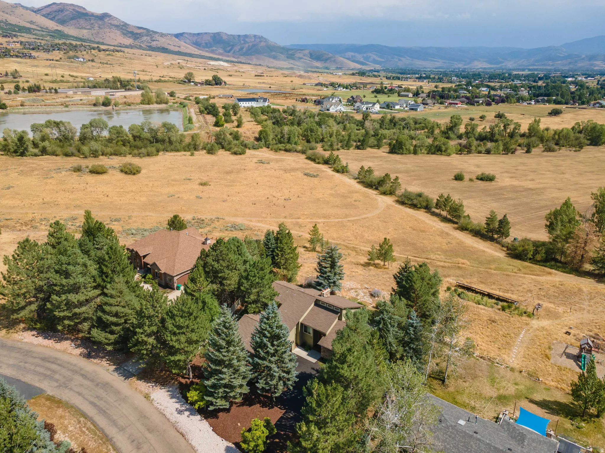 Aerial perspective showcasing the property, encompassing a large body of water, and distant mountain ranges