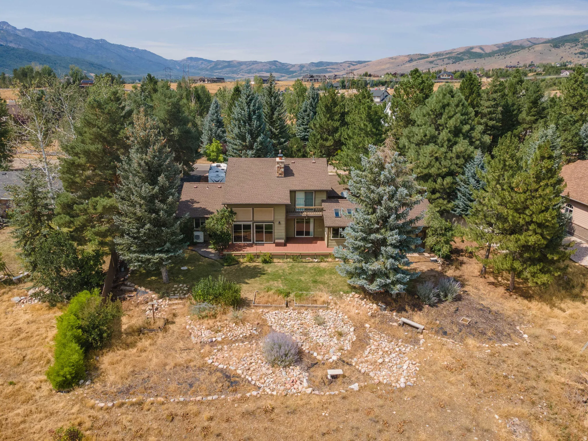 Expansive property featuring a multi-level residence, mature trees, and a terraced hillside