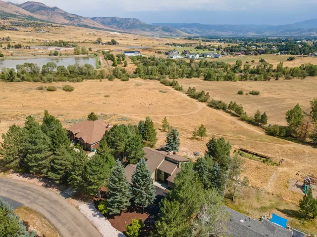 Aerial perspective showcasing the property, encompassing a large body of water, and distant mountain ranges