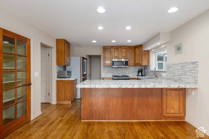 Kitchen featuring wood-finish flooring, recessed lighting, and a kitchen island with stone countertops