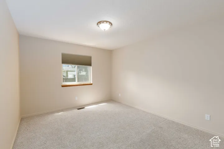 Light-toned walls, neutral carpeting, and a window with a wood-finish sill