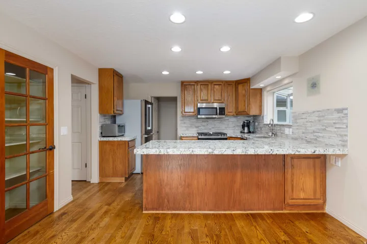 Kitchen featuring wood-finish flooring, recessed lighting, and a kitchen island with stone countertops