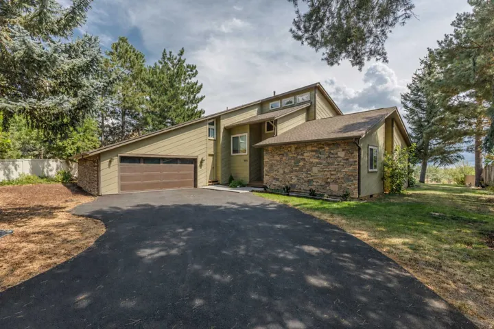 Multi-level exterior with stone veneer accents and a two-car garage