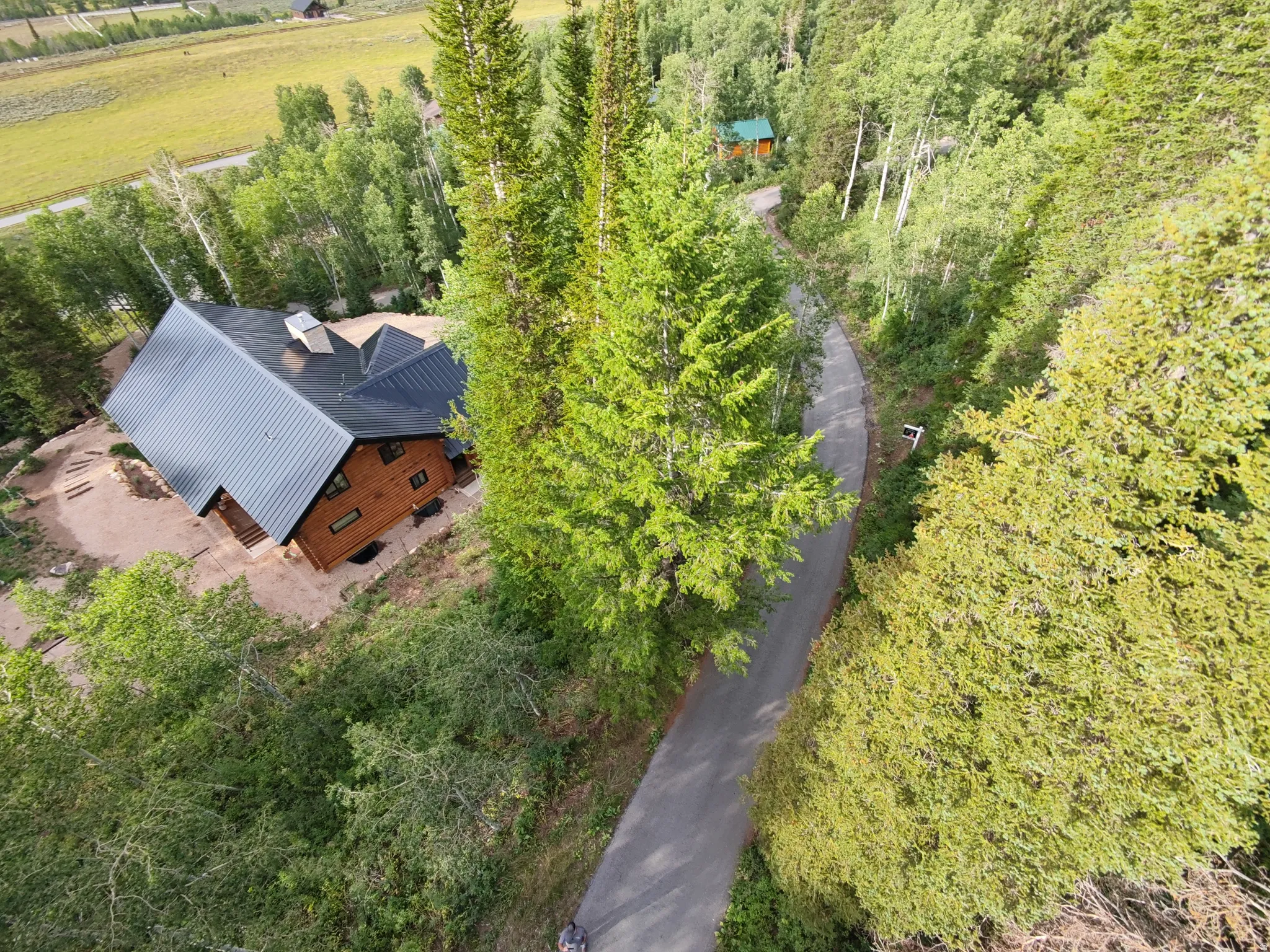 Wood-sided residence featuring a dark metal roof