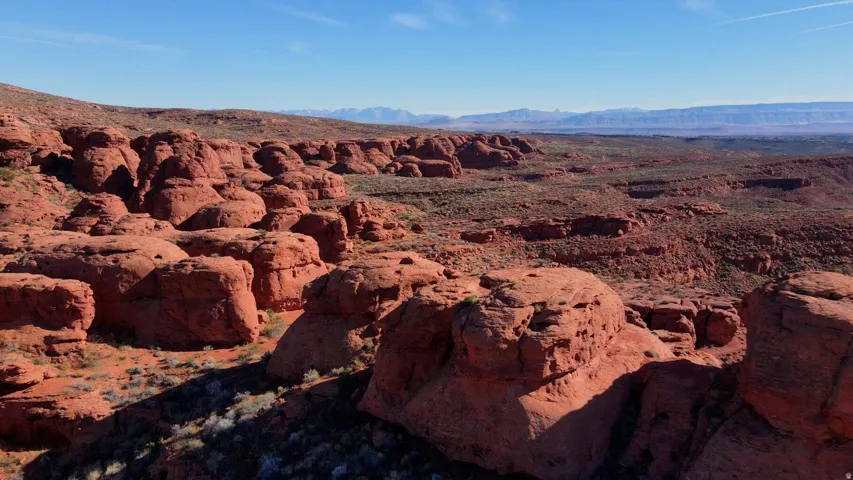 Expansive desert landscape featuring natural rock formations and distant mountain ranges