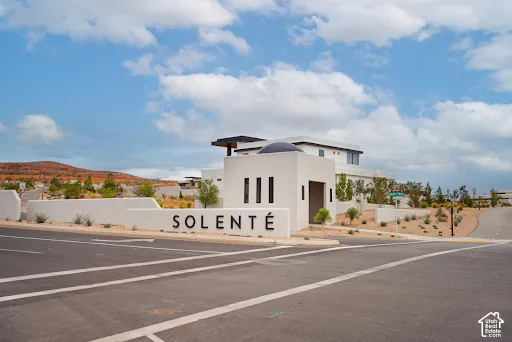 Entry signage featuring a domed architectural element, modern exterior lighting, and integrated landscaping