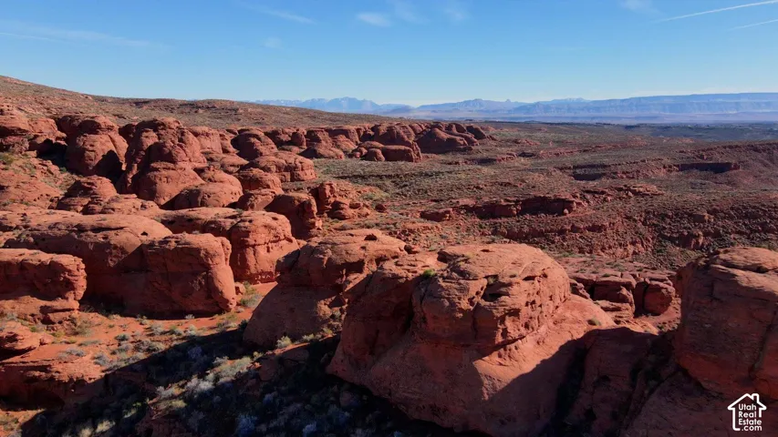 Expansive desert landscape featuring natural rock formations and distant mountain ranges