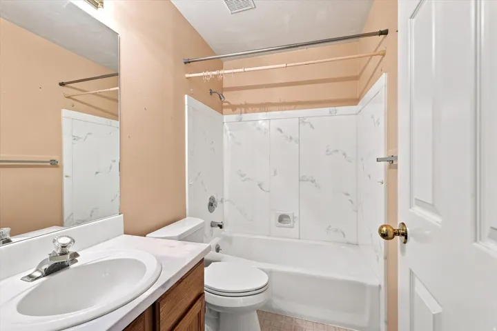 Bathroom featuring a vanity with a white countertop, an integrated sink, and an attached mirror