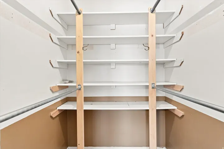 Integrated shelving system with multiple white shelves and metal hanging rods
