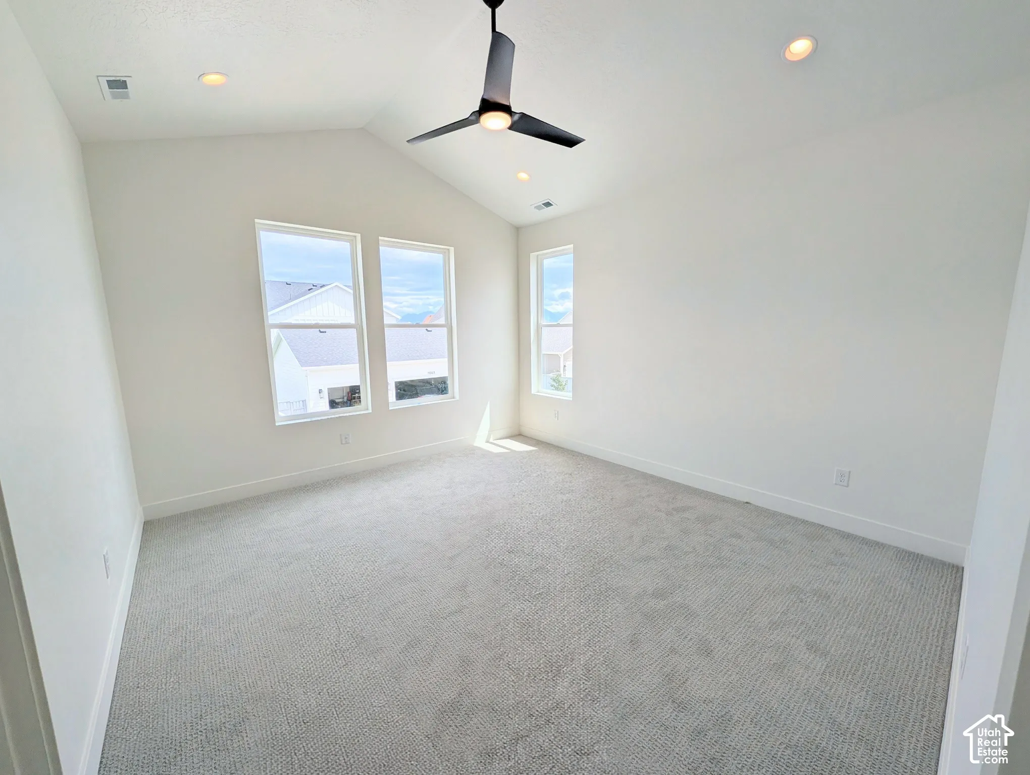 Primary bedroom with Vaulted ceiling, recessed lighting, ceiling fan, carpeting, and multiple windows