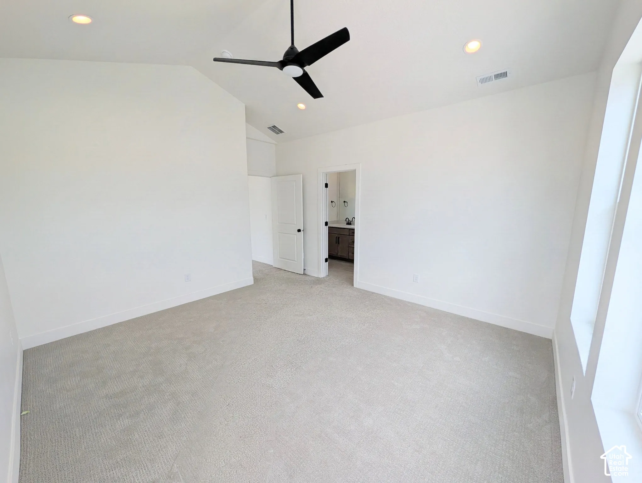 Vaulted ceiling with recessed lighting and a black ceiling fan