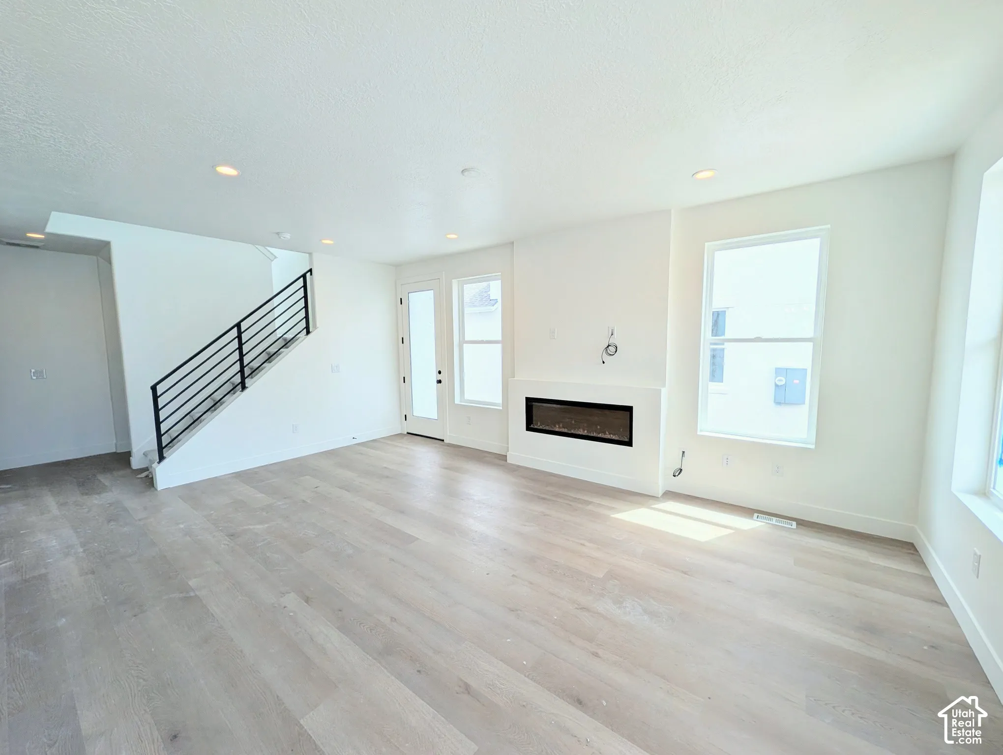 Light wood-finish flooring with recessed ceiling lighting