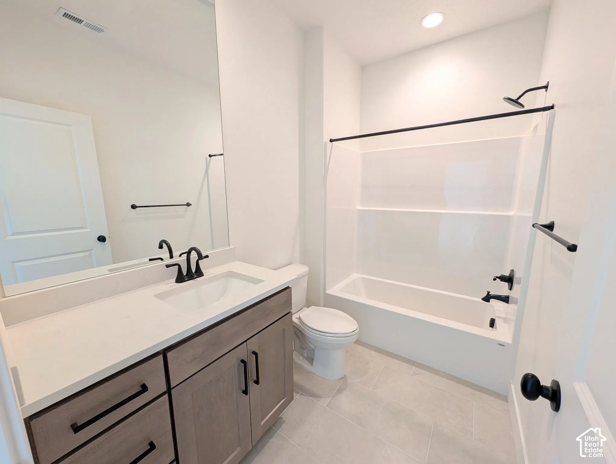 Built-in vanity with light-toned wood-finish cabinetry, white countertop, and integrated sink