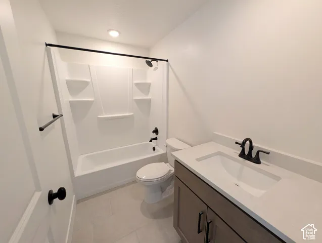 Bathroom with a white bathtub and shower surround, dark bronze fixtures, a vanity with a white countertop, and a built-in sink