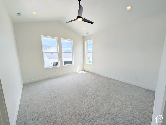 Primary bedroom with Vaulted ceiling, recessed lighting, ceiling fan, carpeting, and multiple windows