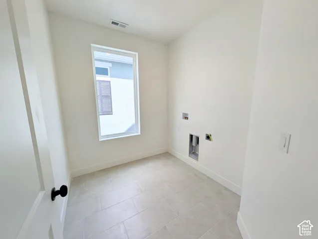 White walls, tile flooring, and a single window with white trim