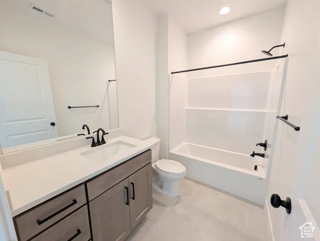 Built-in vanity with light-toned wood-finish cabinetry, white countertop, and integrated sink