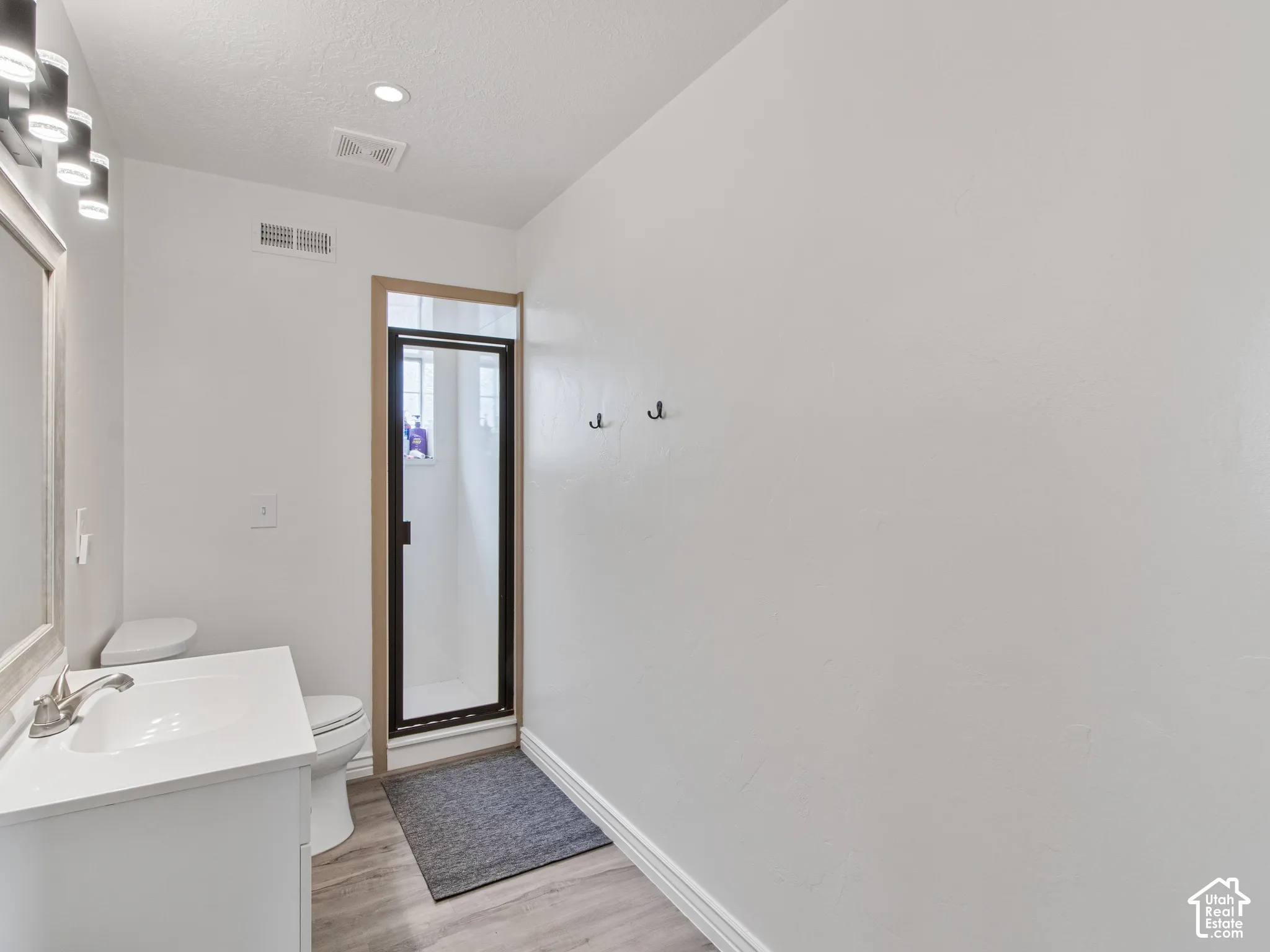 Guest restroom. White vanity with an integrated sink, brushed nickel faucet, and a framed mirror