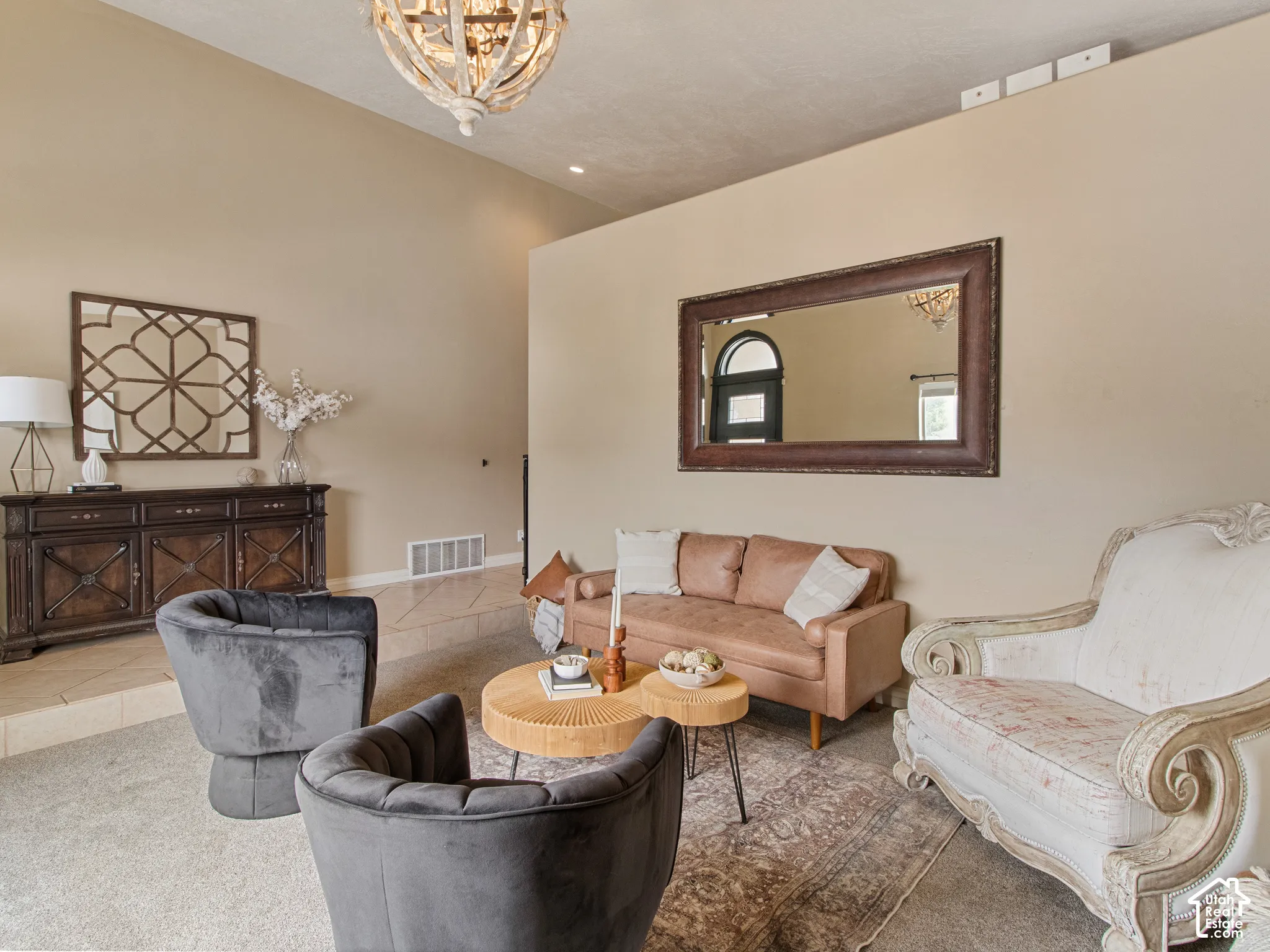 Vaulted ceiling with an ornate chandelier, neutral wall tones, and recessed lighting