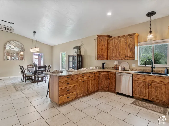 Open layout, Kitchen featuring wood cabinetry, granite-style countertops, stainless steel dishwasher, and a black single-basin sink with a matte black faucet