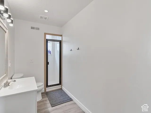 Guest restroom. White vanity with an integrated sink, brushed nickel faucet, and a framed mirror