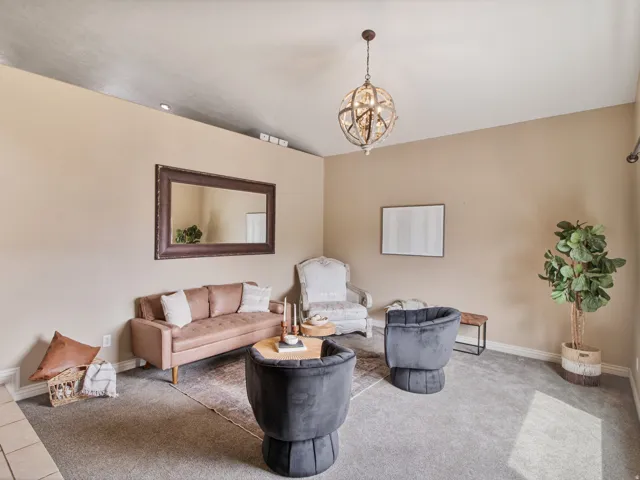 Formal living room. High ceilings with a decorative spherical chandelier and recessed lighting