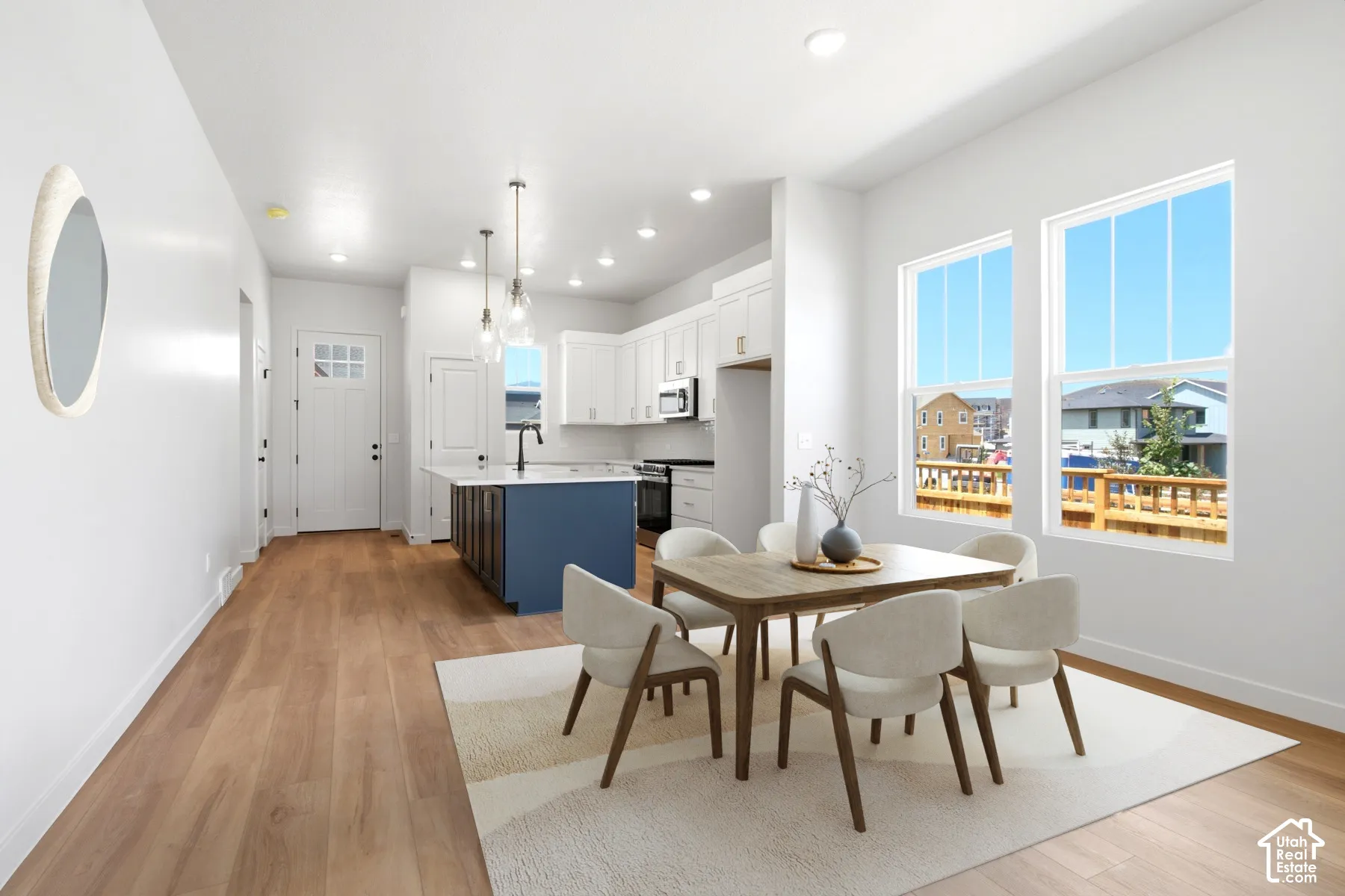 Light wood-finish flooring throughout, white walls, and recessed lighting
