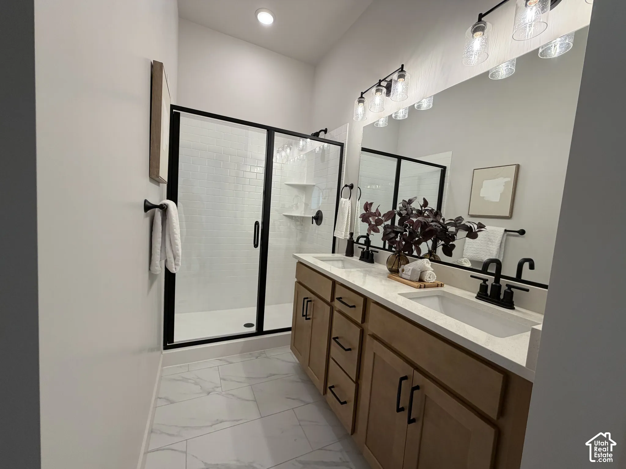 Dual vanity with light wood-finish cabinetry and matte black hardware