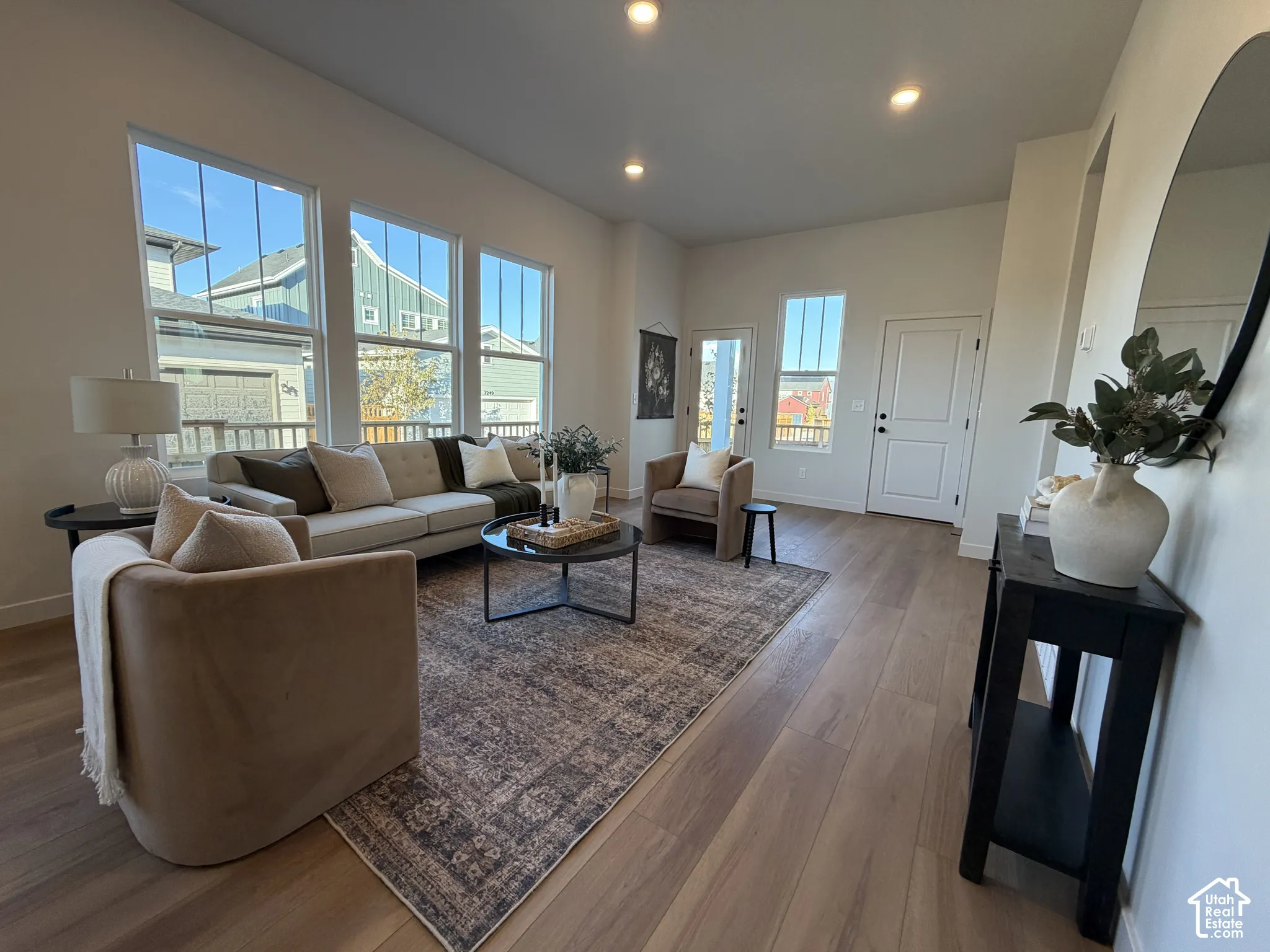 Open-concept living space with wood-finish flooring, recessed lighting, and multiple large windows