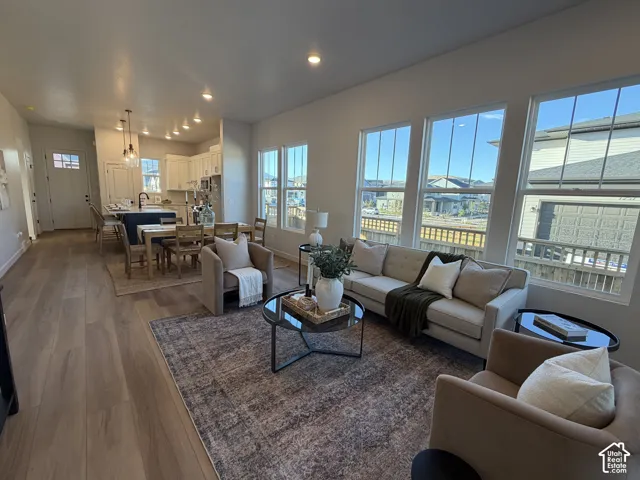 Open-concept living area with wood-finish flooring, recessed lighting, and multiple windows