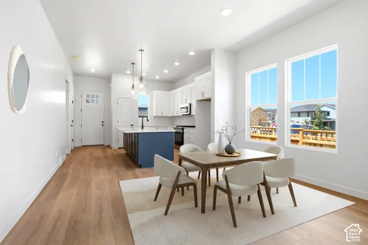 Light wood-finish flooring throughout, white walls, and recessed lighting