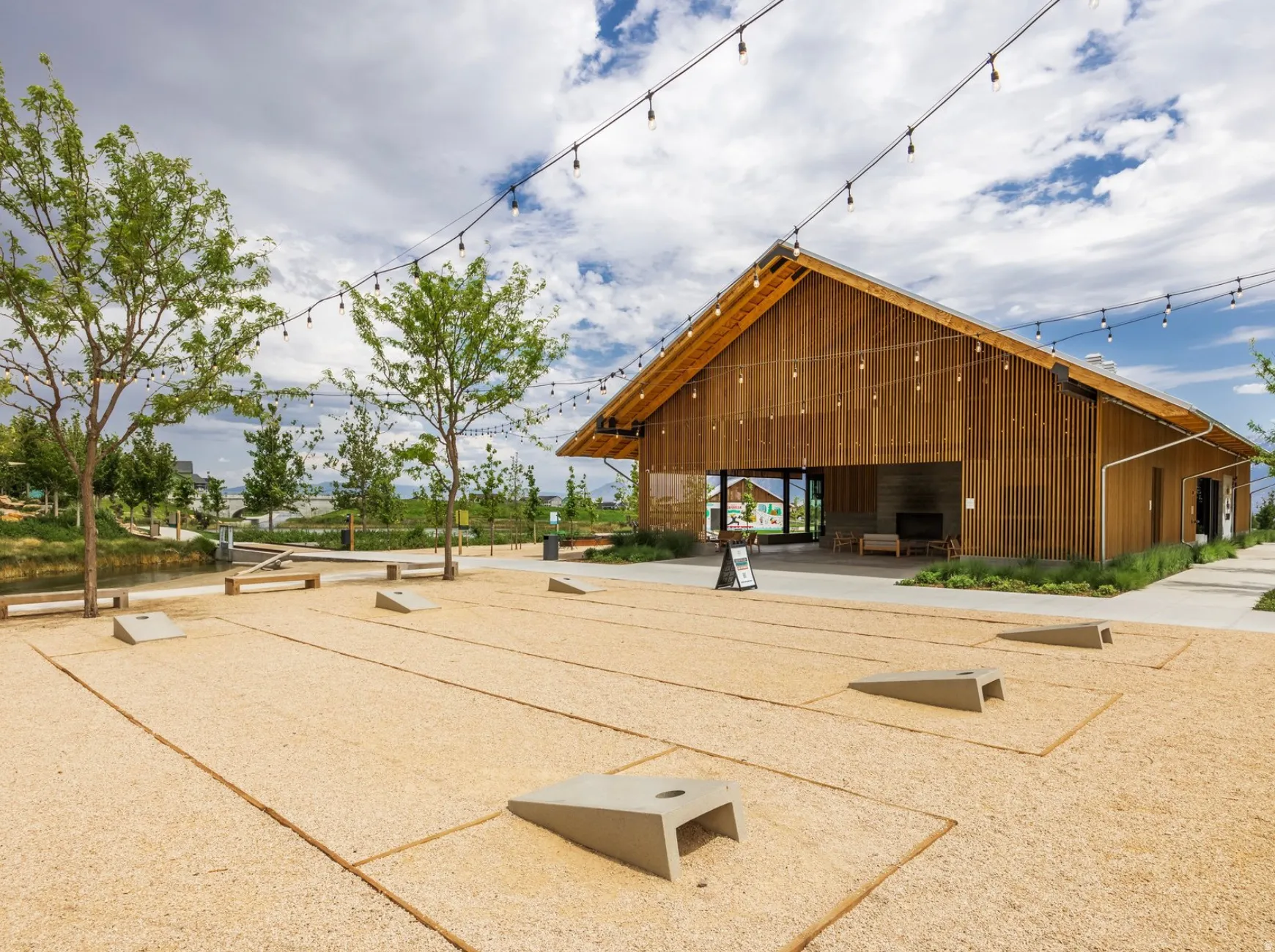 Barn-style architectural structure featuring expansive wooden siding and an open-air gathering area with a fireplace