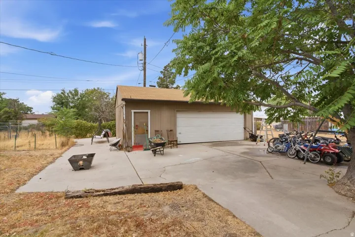 Detached garage with a single roll-up door, side-entry door, and concrete driveway