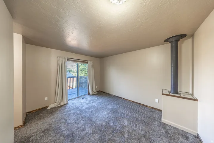 Spacious room featuring gray textured carpeting and neutral wall paint