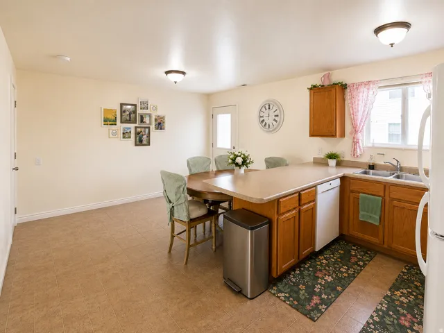Kitchen featuring wood cabinetry, laminate countertops, a double basin sink, and a built-in dishwasher