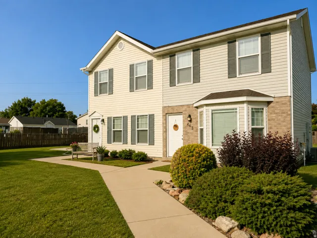 Two-story exterior with light-colored siding and dark shutters