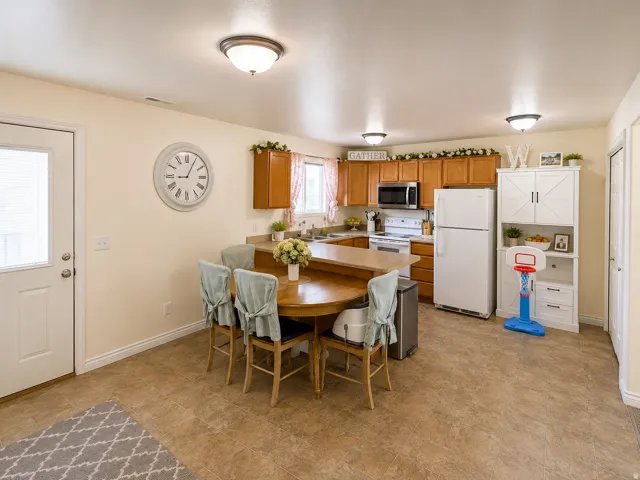 Recessed lighting, wood-finish cabinetry, built-in microwave, white refrigerator, and a kitchen island with a breakfast bar