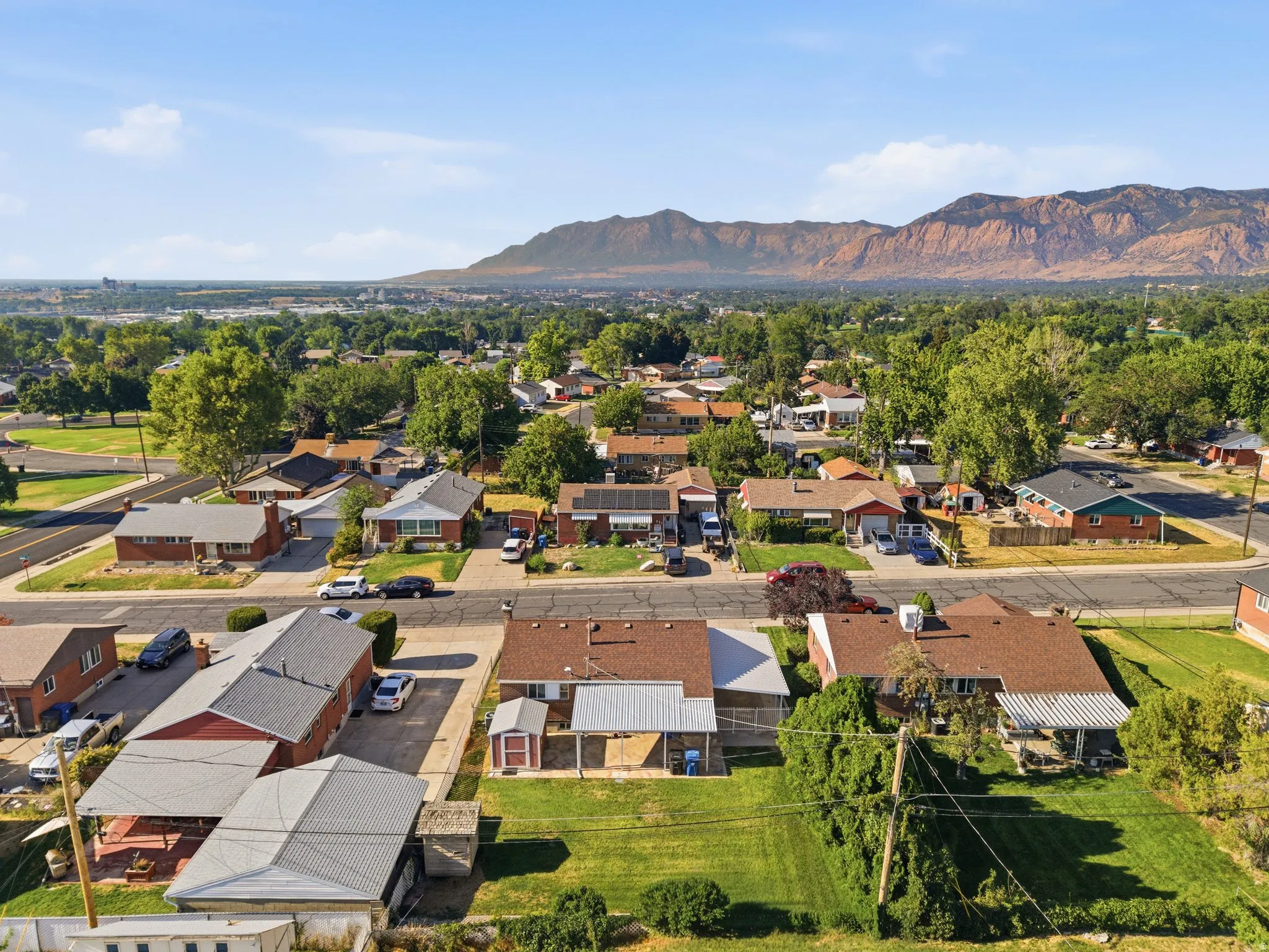 Expansive neighborhood setting with established homes, mature trees, and mountainous backdrop