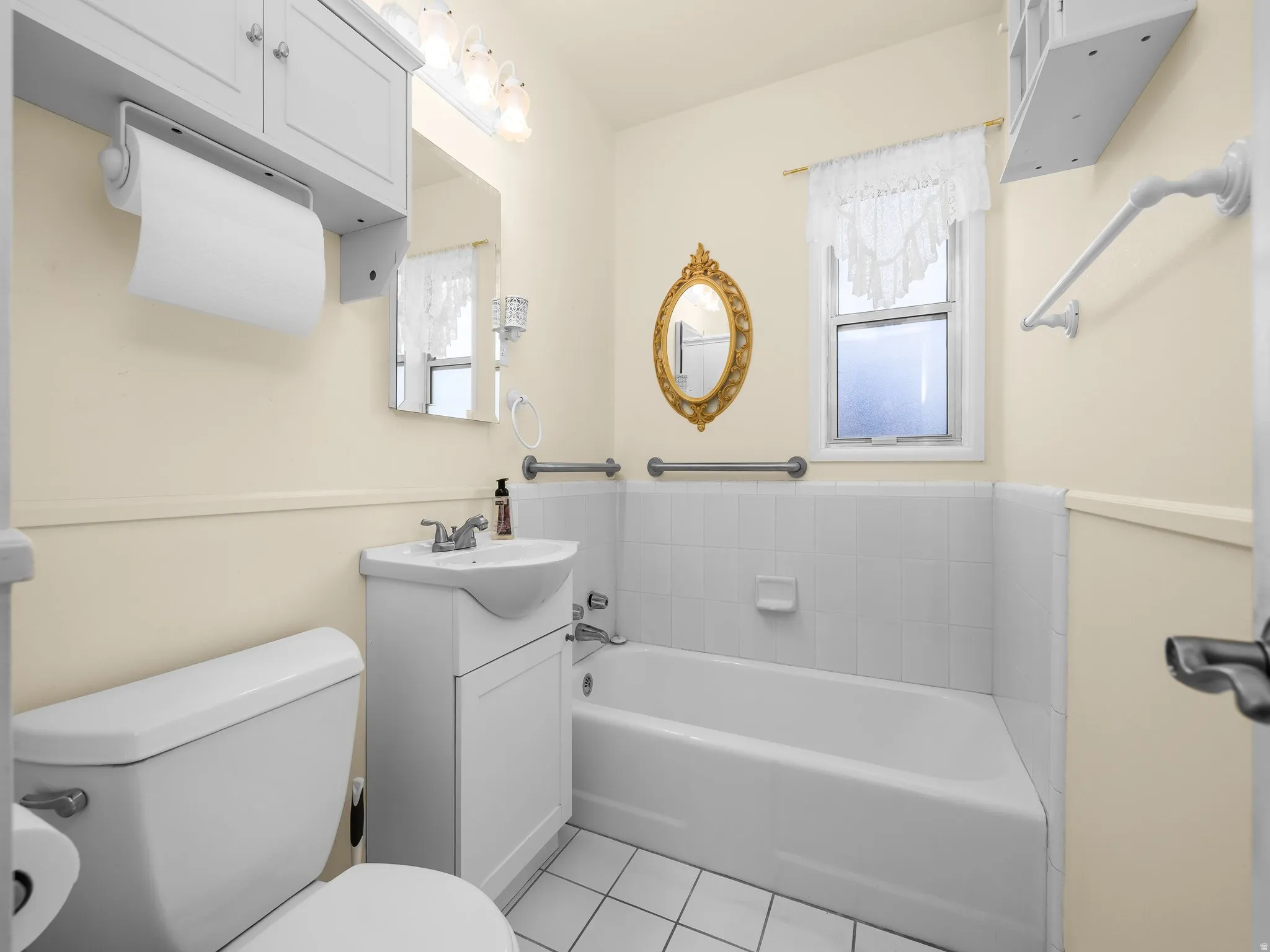 White-tiled bathtub with a wall-mounted grab bar