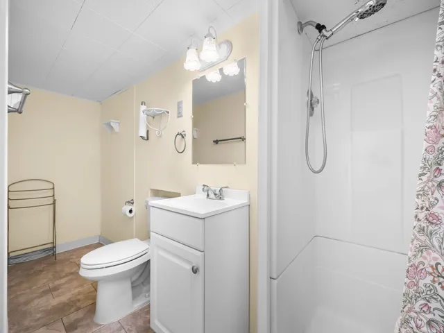 White vanity with integrated sink, chrome faucet, and mirrored medicine cabinet