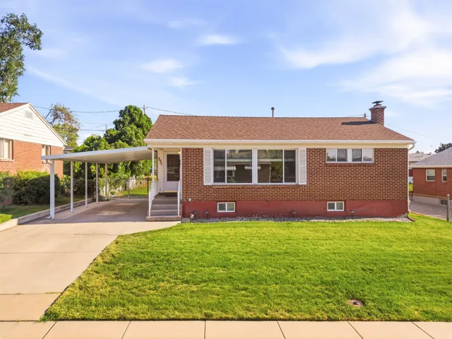 Brick exterior with a shingle roof and a covered carport