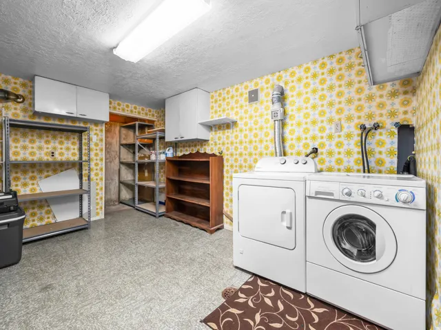Laundry area with textured flooring, white wall-mounted cabinetry, and metal shelving units