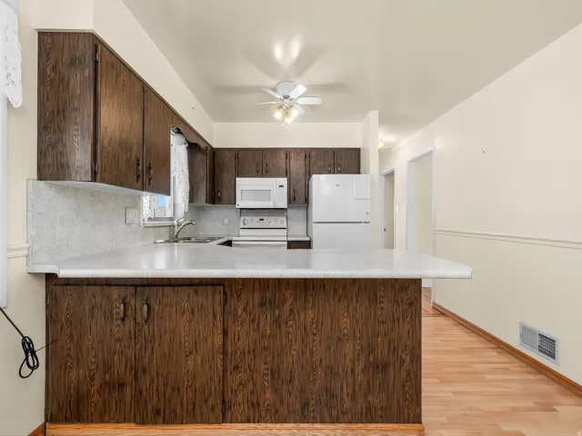 Wood-finish cabinetry with white countertops
