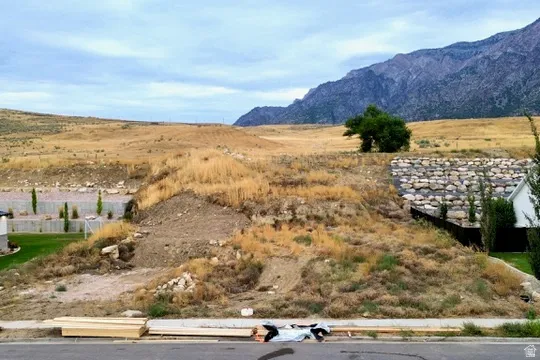 Generous sloped lot with a substantial retaining wall and mature mountain scenery