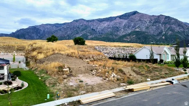 Mountain backdrop, undeveloped lot, street frontage, established neighborhood, partial retaining wall