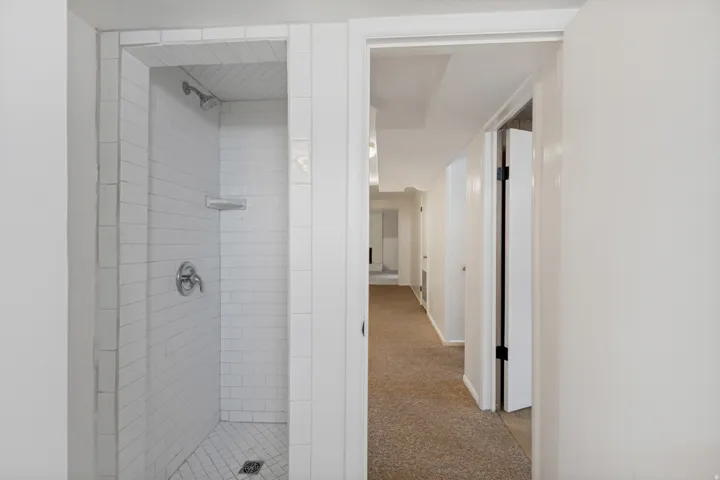 White subway tile shower enclosure with a chrome shower head and fixtures