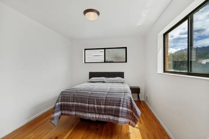 Hardwood flooring, white walls, and a flush-mount ceiling light