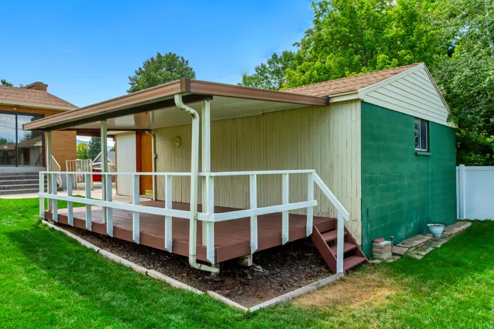 Covered outdoor deck with wooden railing and integrated stairs